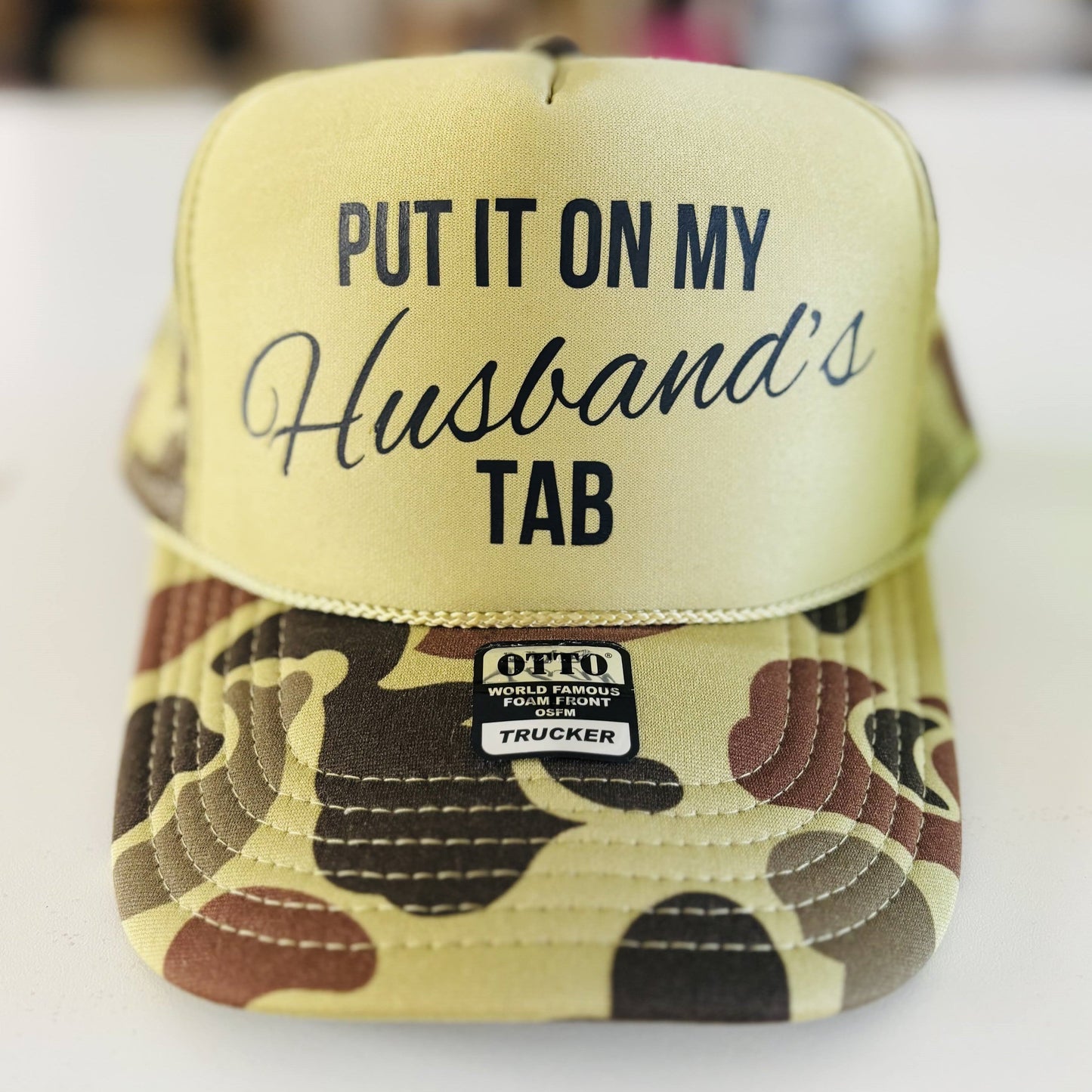 Put It On My Husbands Tab Trucker Hat